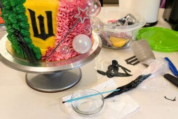 a paintbrush with a bowl of Everclear next to a Wicked cake