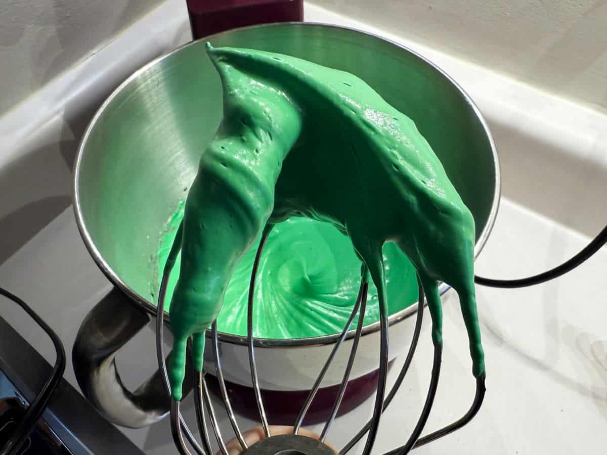 green meringue in a stiff peak on a wire whisk