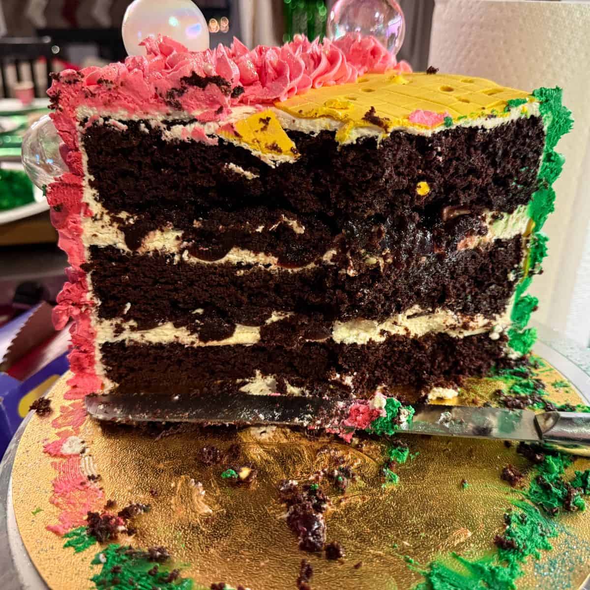 a Wicked Birthday Cake cut open to reveal a Black Forest Cake inside with chocolate cake, whipped cream and Amarena cherries