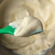 Eggnog Pastry Cream on a green silicone spatula held over a bowl with the cream