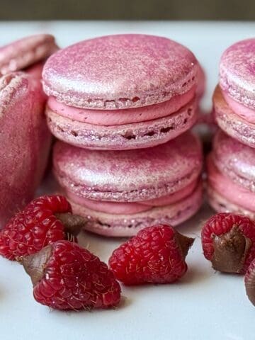 Nut Free Raspberry Truffle Macarons on a white plate with truffled raspberries
