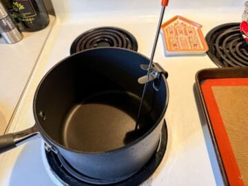 an empty saucepan with a candy thermometer in it