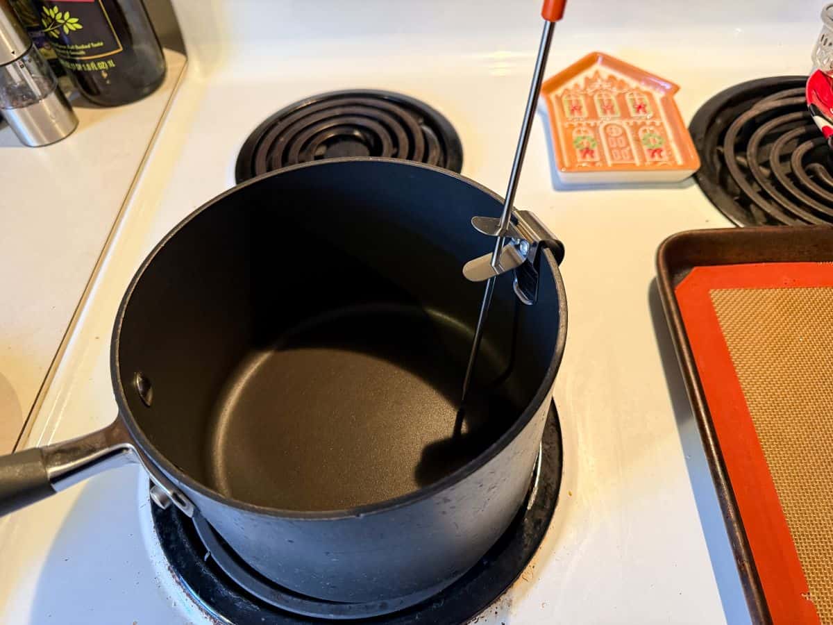 an empty saucepan with a candy thermometer in it