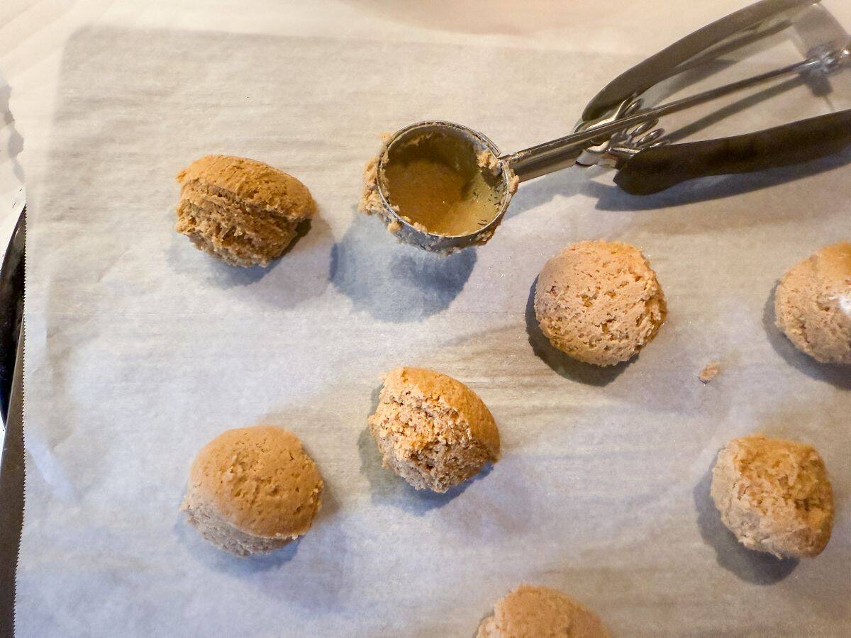 scoops of cookie dough on a parchment lined cookie sheet