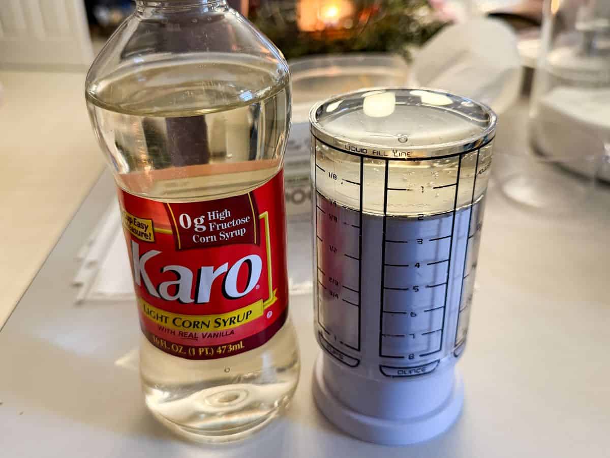 a jar of Karo light corn syrup next to a honey measuring cup filled with the syrup