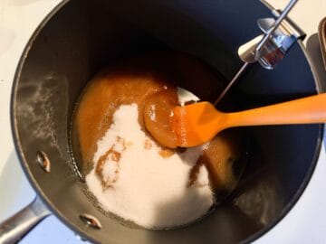 sugar, coffee and corn syrup in a saucepan being stirred with a small silicone spatula