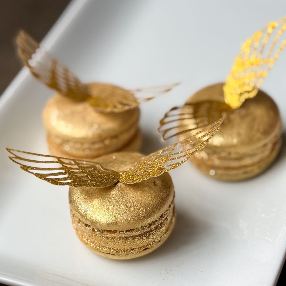 Nut Free Golden Snitch Macarons on a white plate
