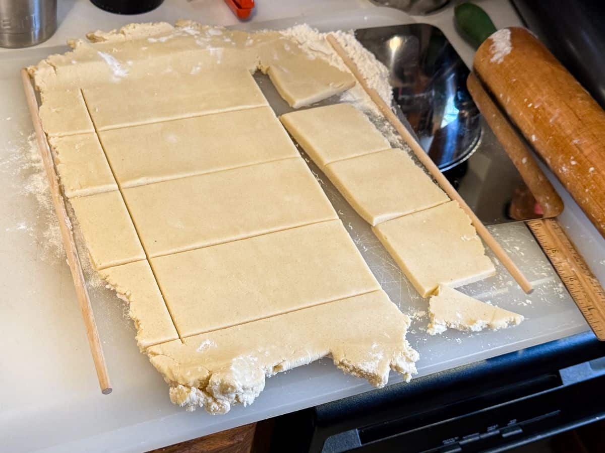 cookie dough rolled to an even thickness on a counter and cut into rectangles using a ruler and straight edge