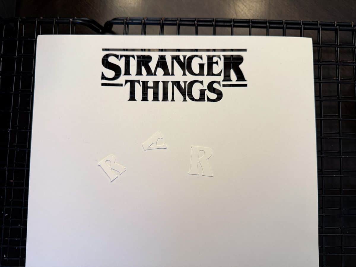 the Stranger Things logo cut out of white cardstock