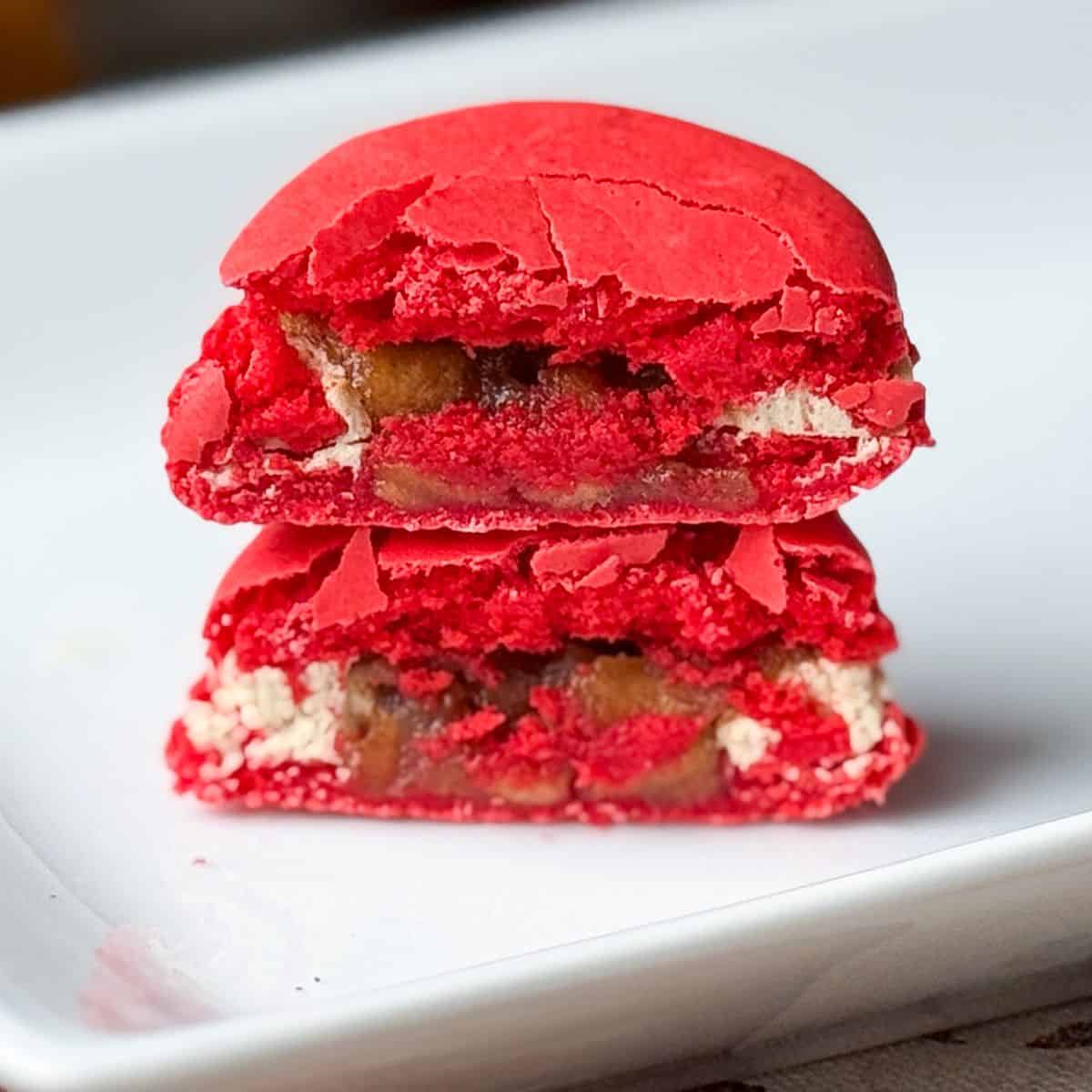 an apple macchiato macaron cut in half and stacked to show the filling inside