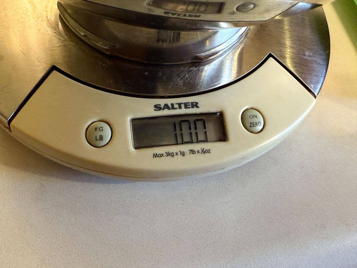 a digital kitchen scale reading 100 grams with a bowl on top