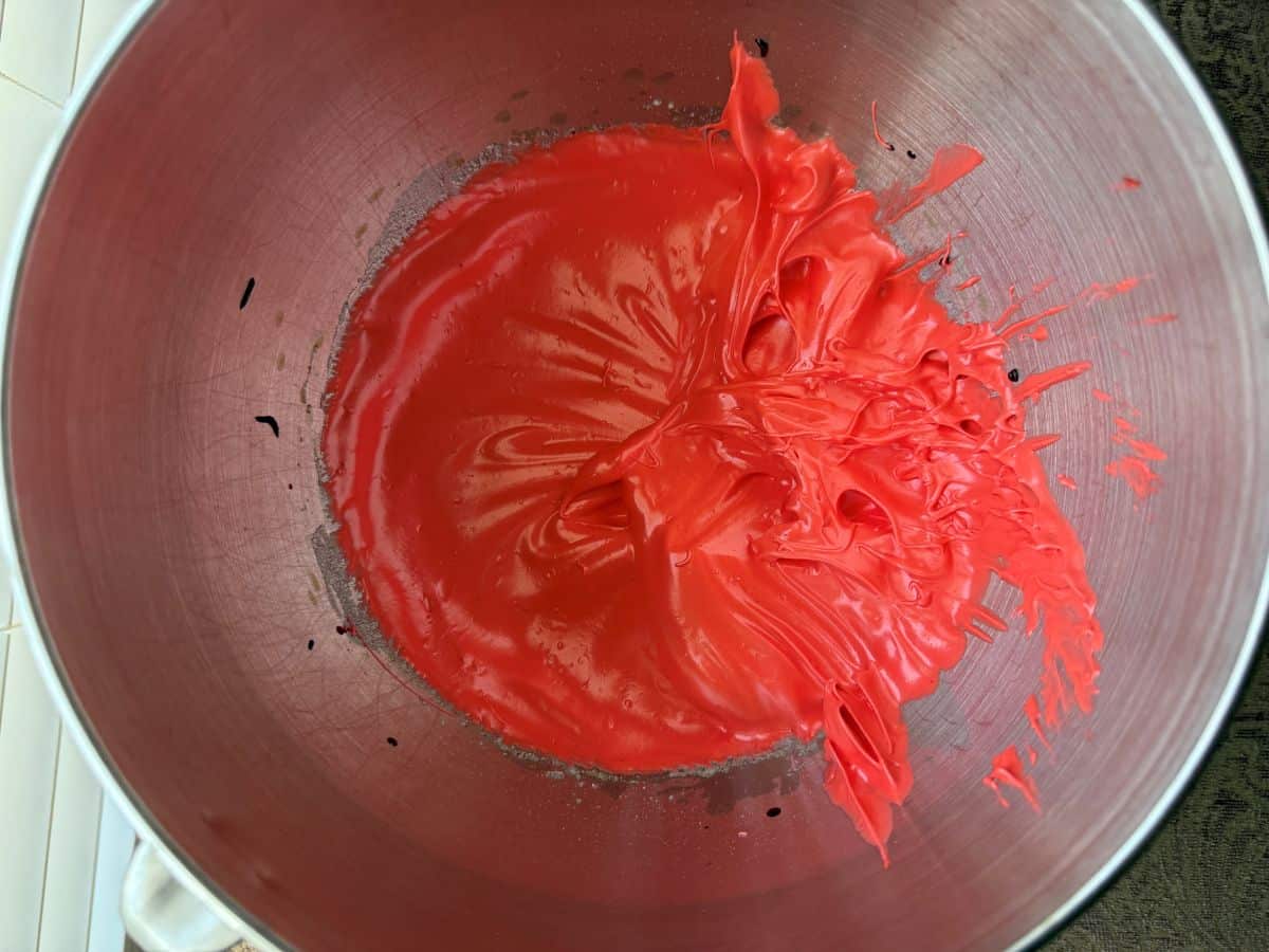 red stiff peak meringue in the bowl of a stand mixer