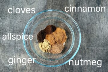 a small glass bowl filled with fall spices and labeled with the names of the spices