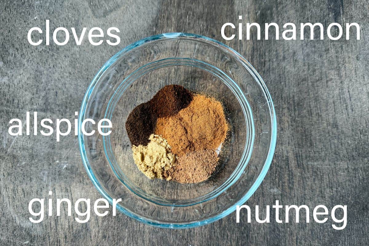 a small glass bowl filled with fall spices and labeled with the names of the spices