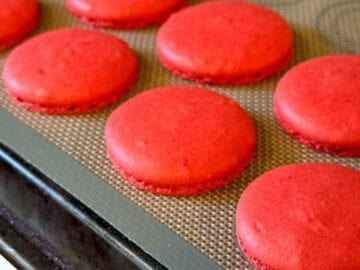 red macaron shells baked on a macaron mat