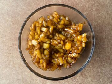 a glass bowl filled with caramel apple filling