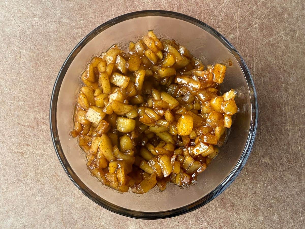 a glass bowl filled with caramel apple filling