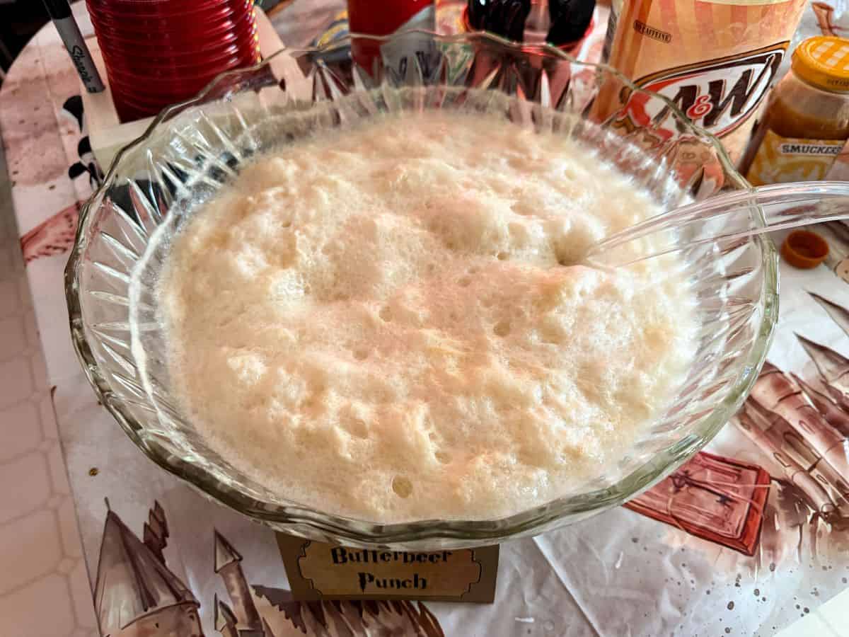 Butterbeer Punch in a glass punch bowl with a ladle