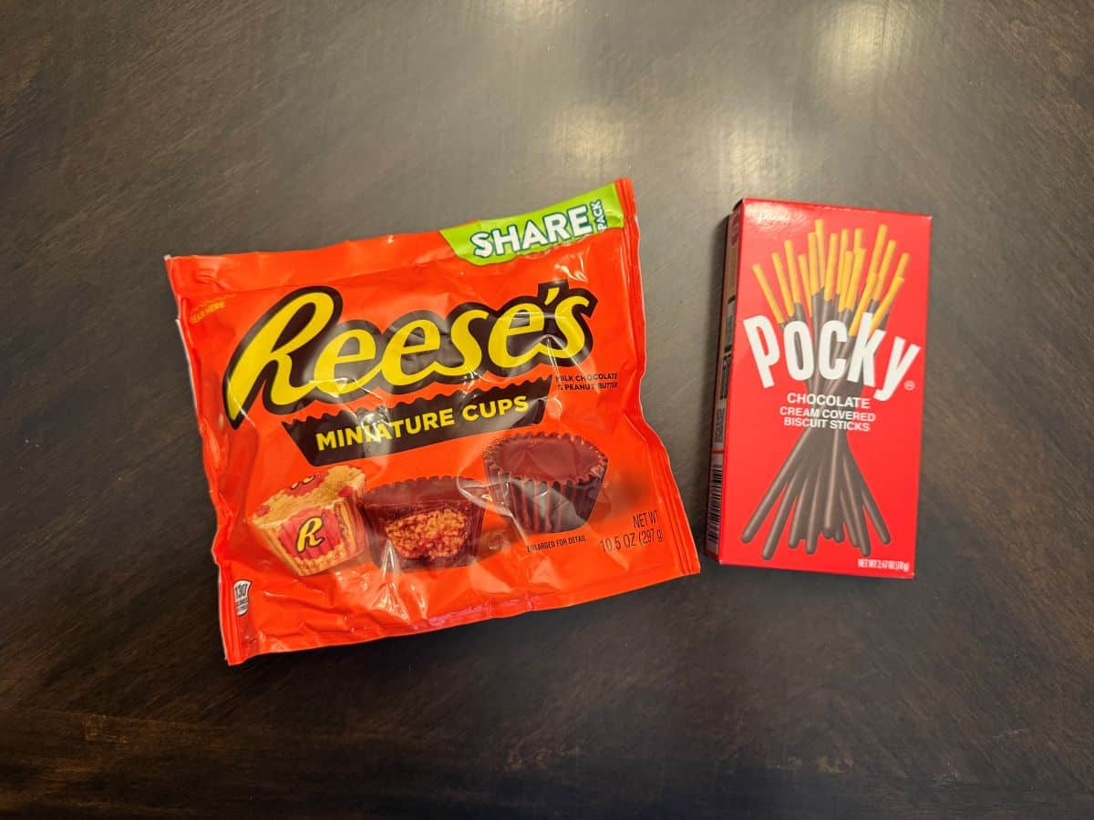 a bag of Reese's miniatures peanut butter cups next to a box of pocky sticks cookies