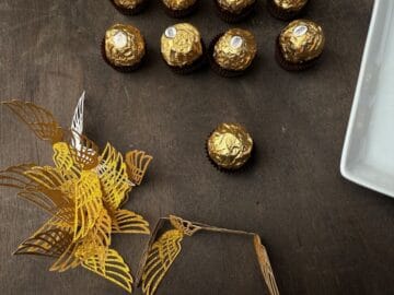 Ferrero Rocher candies next to a folded glitter cardstock wings