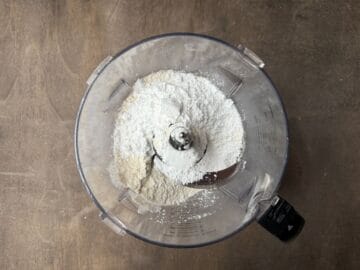 dry ingredients for a tart shell in the bowl of a food processor