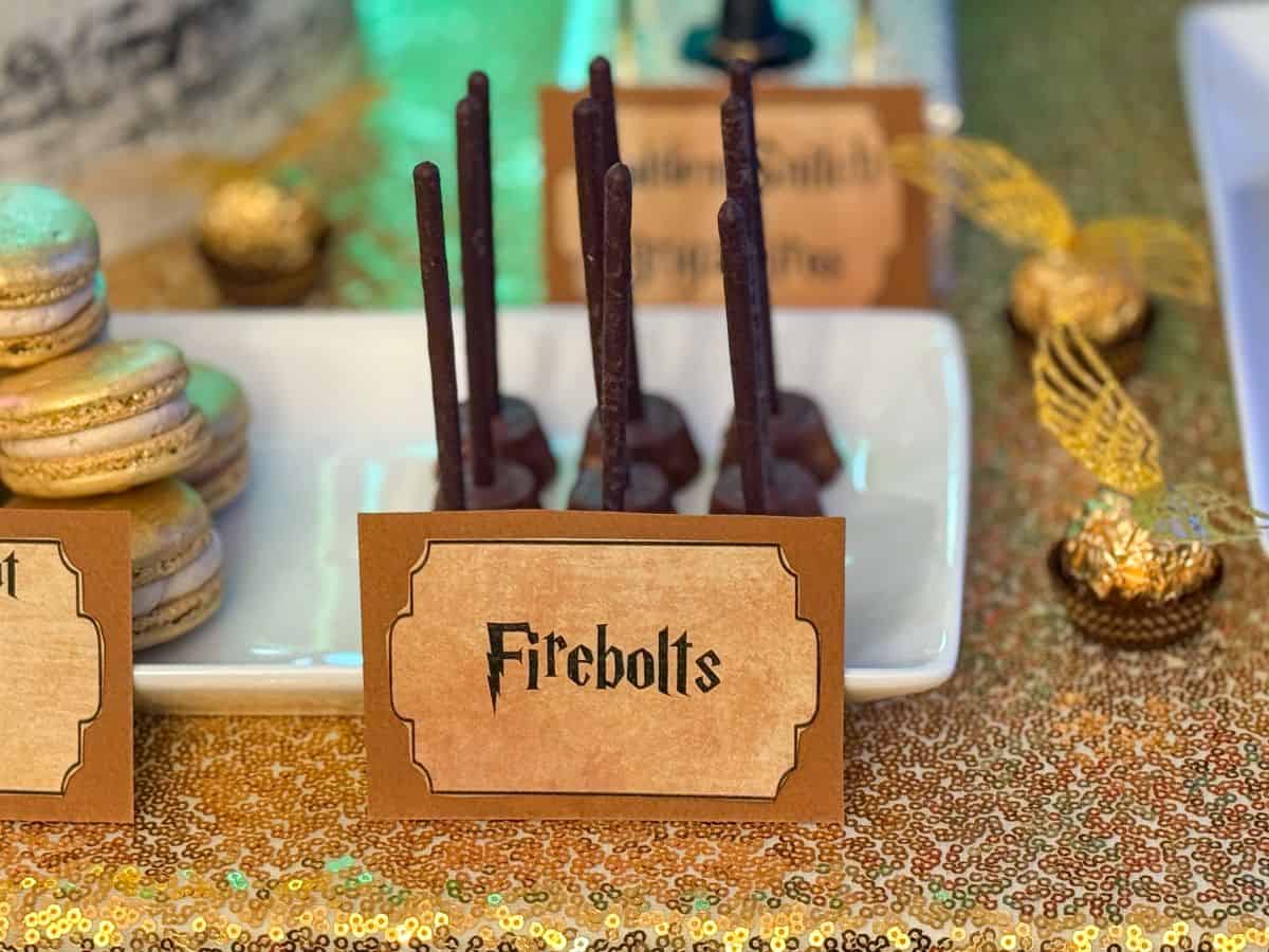 chocolate broomstick candies labeled "Firebolts" on a Harry Potter dessert table