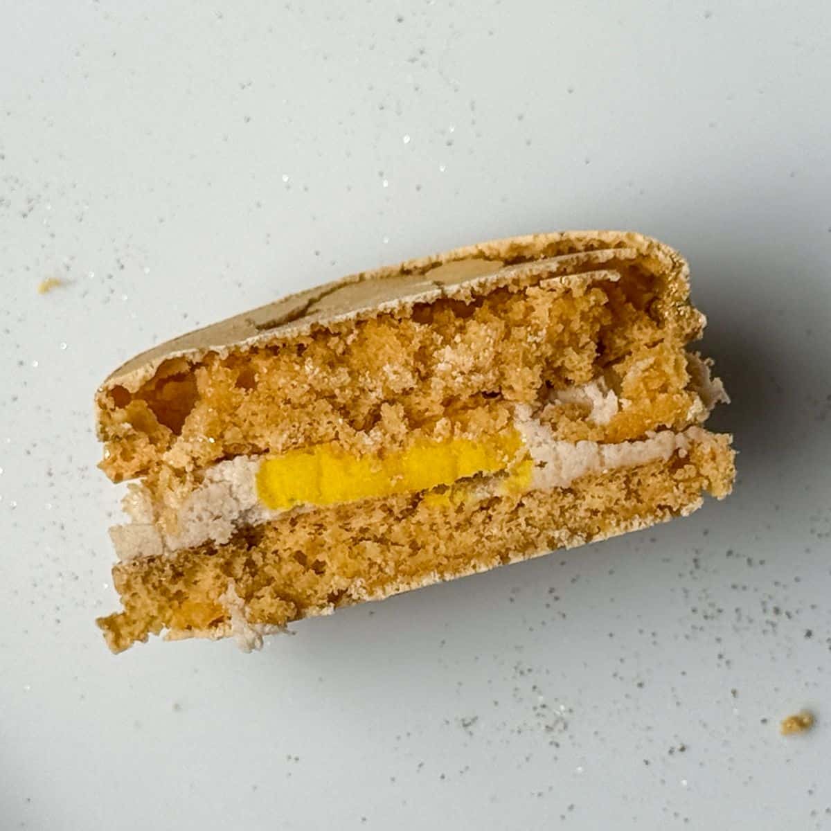 a Sorting Hat Butterbeer Macaron cut in half to show the yellow inside