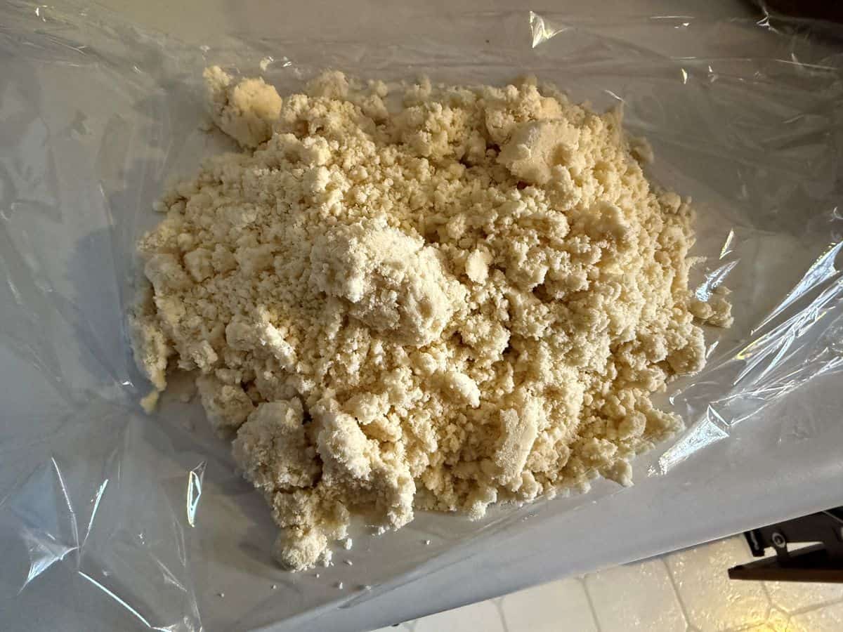 lumpy tart shell dough on a piece of plastic wrap before being pressed together