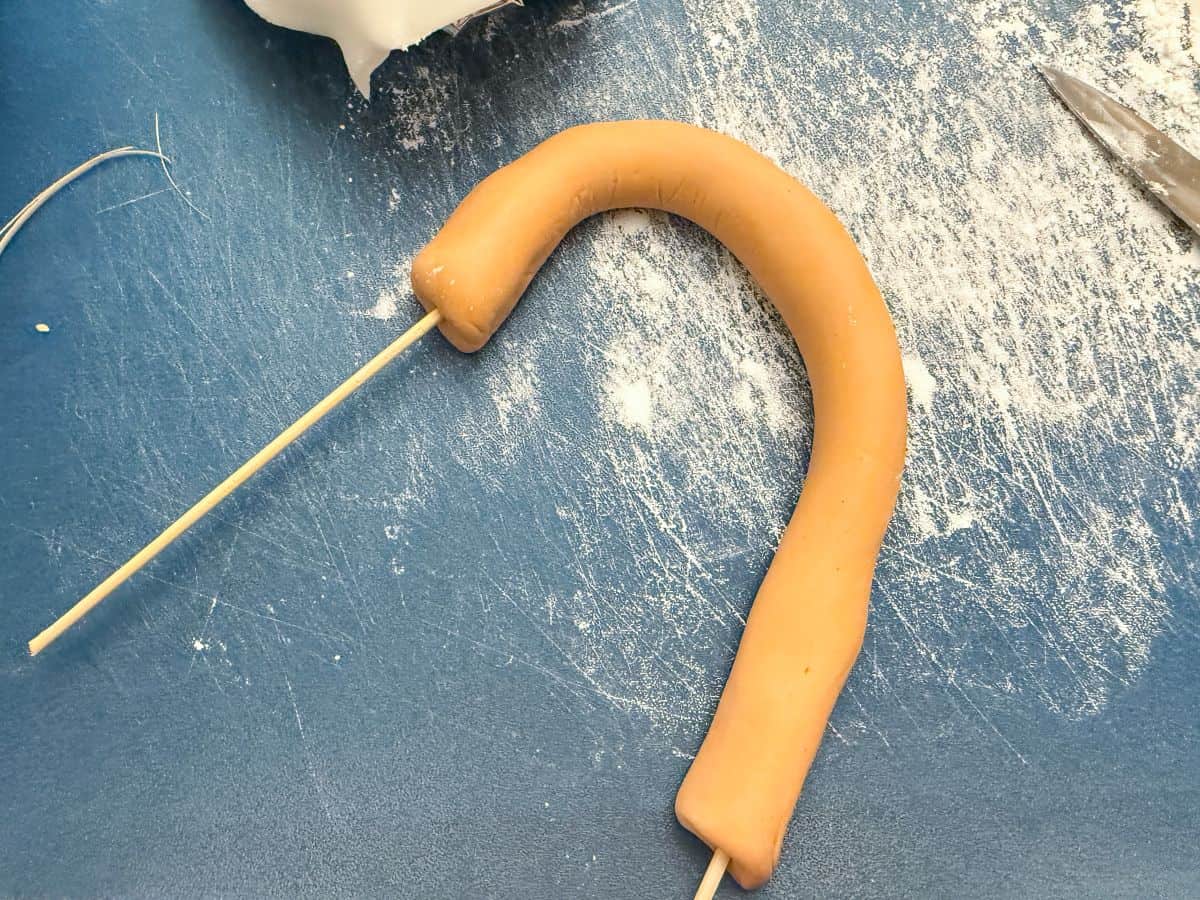 gold colored fondant shaped into a handle with wooden skewers in each end