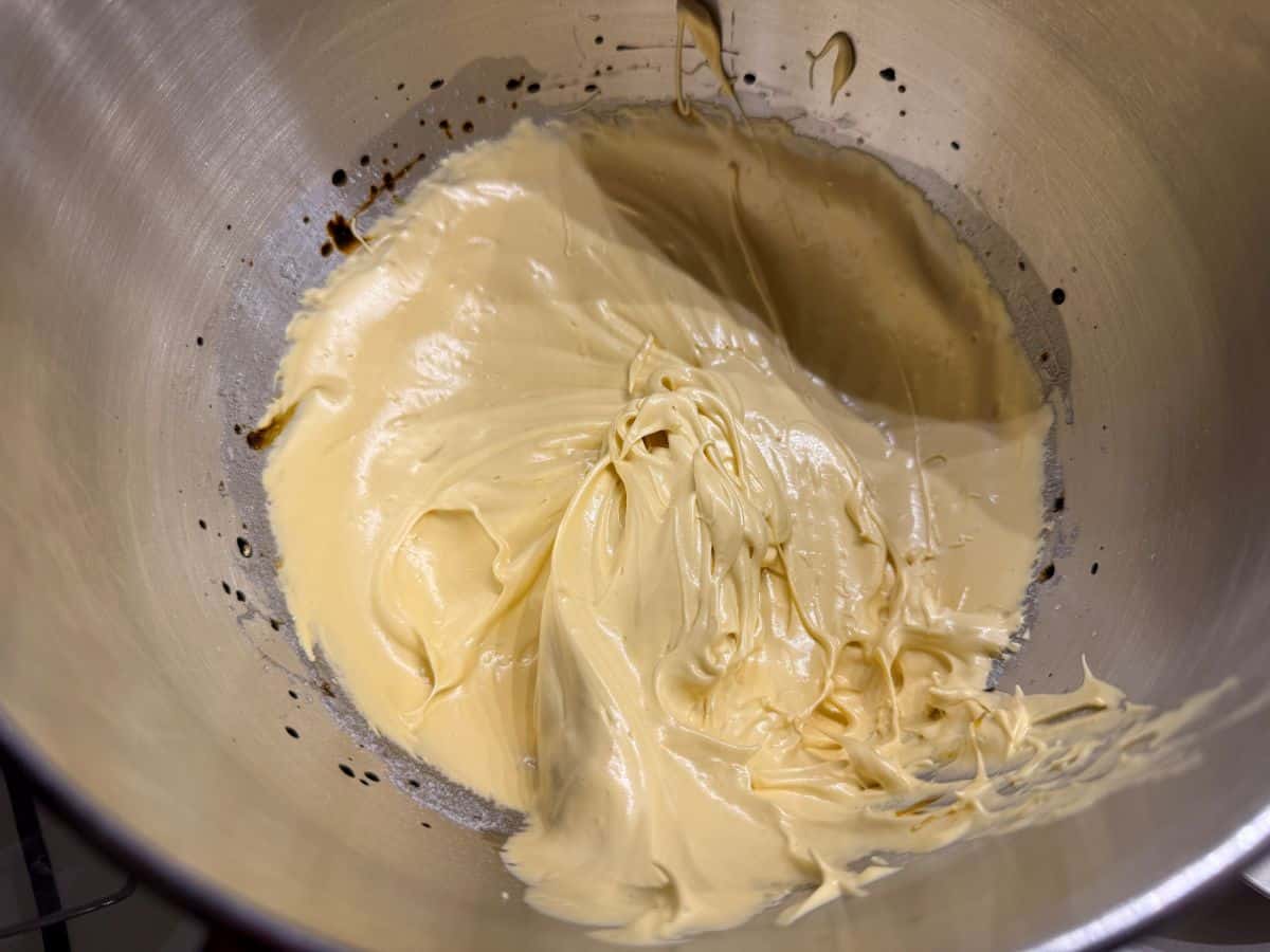 gold tinted meringue in a metal stand mixer bowl