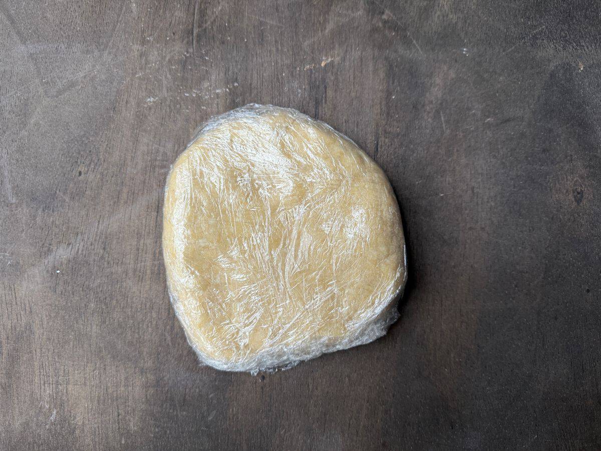 a round disk of tart shell dough wrapped in plastic wrap