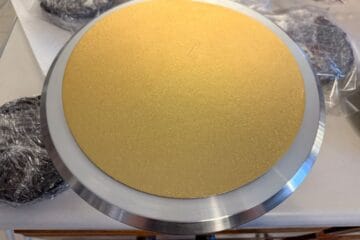 a gold cake board on top of a spinning cake stand