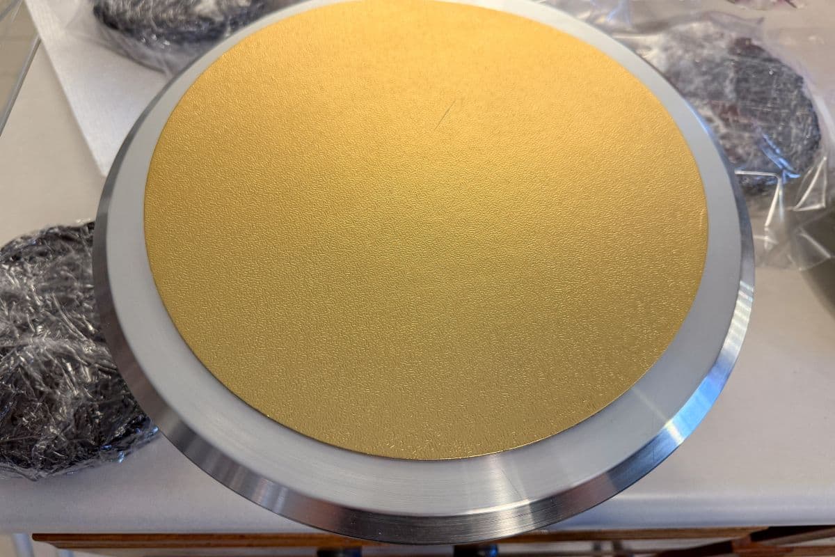 a gold cake board on top of a spinning cake stand