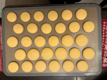 gold colored macaron shells baked on a macaron mat