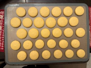 gold colored macaron shells baked on a macaron mat