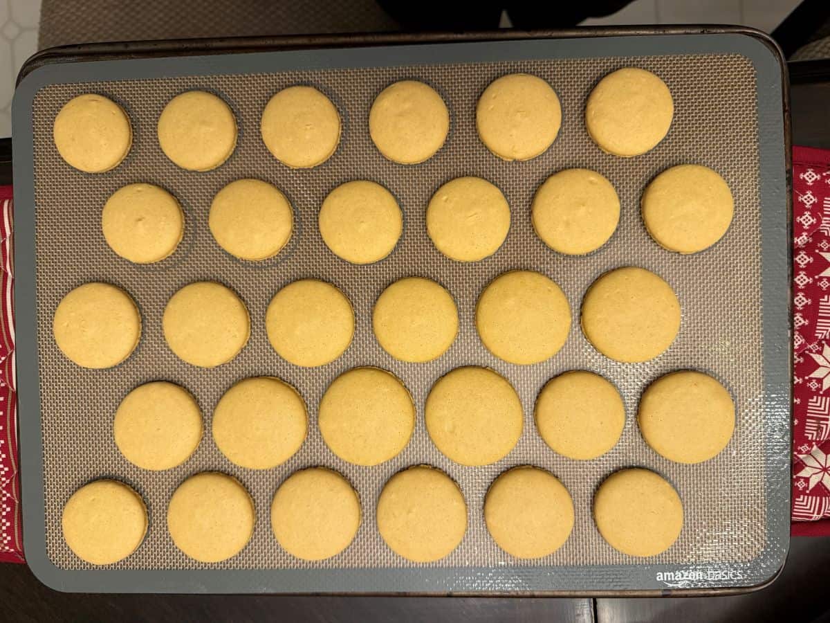 gold colored macaron shells baked on a macaron mat