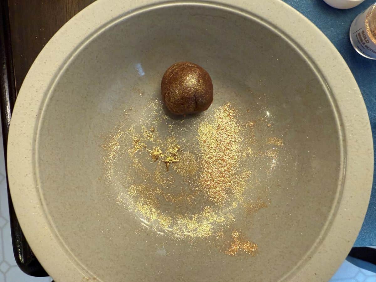 a ball of fudge in a bowl with some edible gold glitter