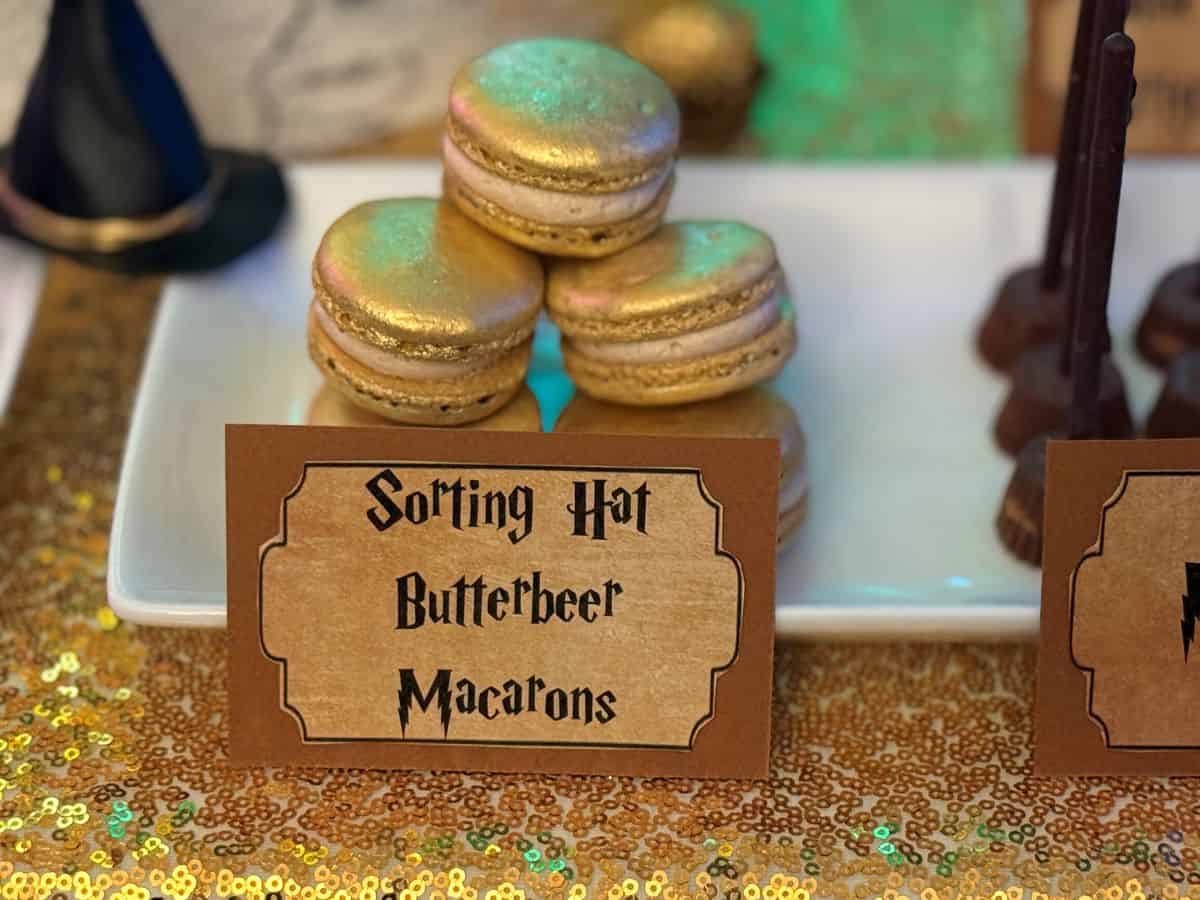 Sorting Hat Butterbeer Macarons on a dessert table with a food label