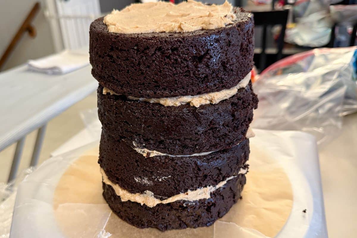 4 layers of chocolate cake stacked up with butterscotch buttercream between the layers and on top