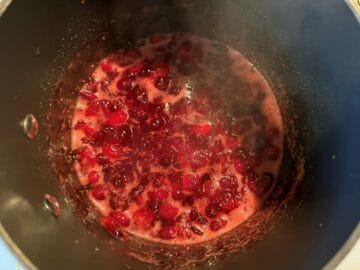 cranberries bursting in a saucepan on the stove
