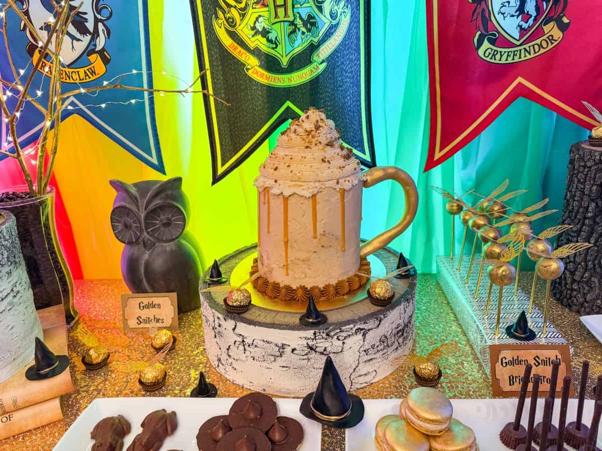 a Harry Potter dessert table with a Butterbeer Cake in the middle