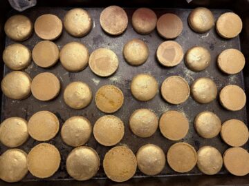 macaron shells paired up and painted with gold luster dust
