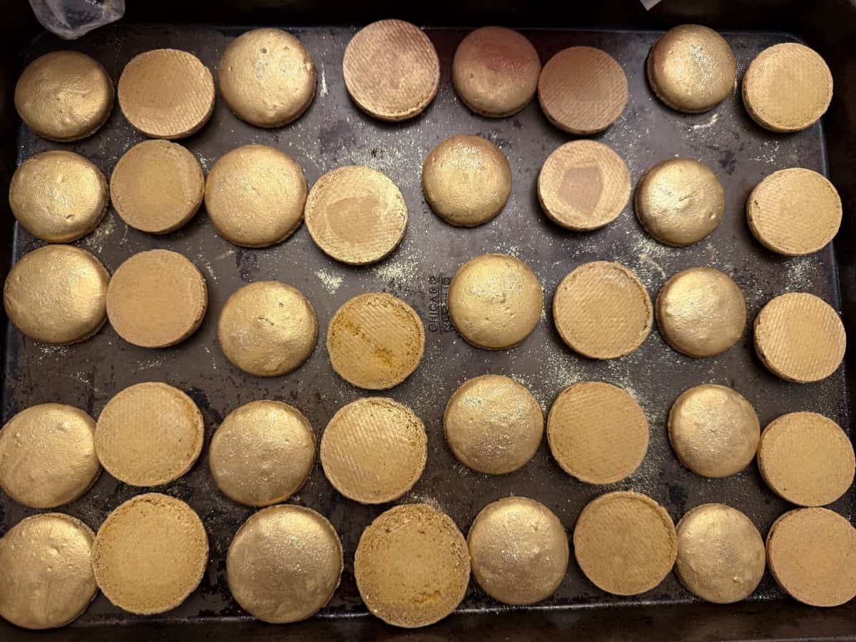 macaron shells paired up and painted with gold luster dust