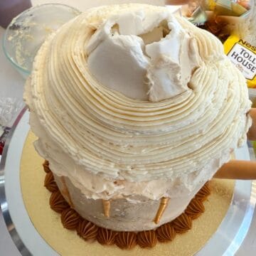 vanilla buttercream piped around a white fondant cone on top of a Butterbeer Cake