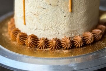 warm brown colored buttercream piped around the base of a Butterbeer Cake