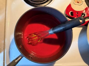 cranberry curd in a saucepan with a whisk