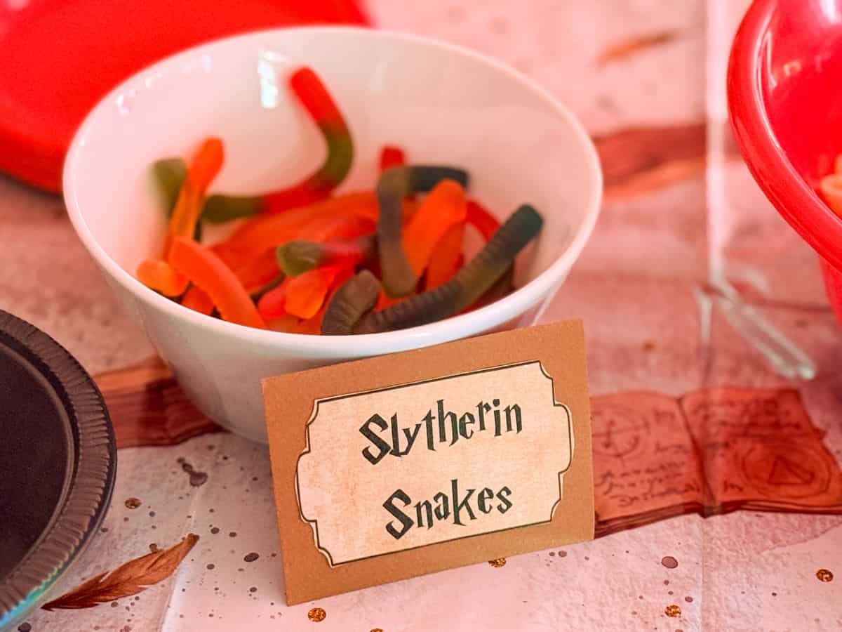 a bowl of gummy worms labeled "Slytherin Snakes"