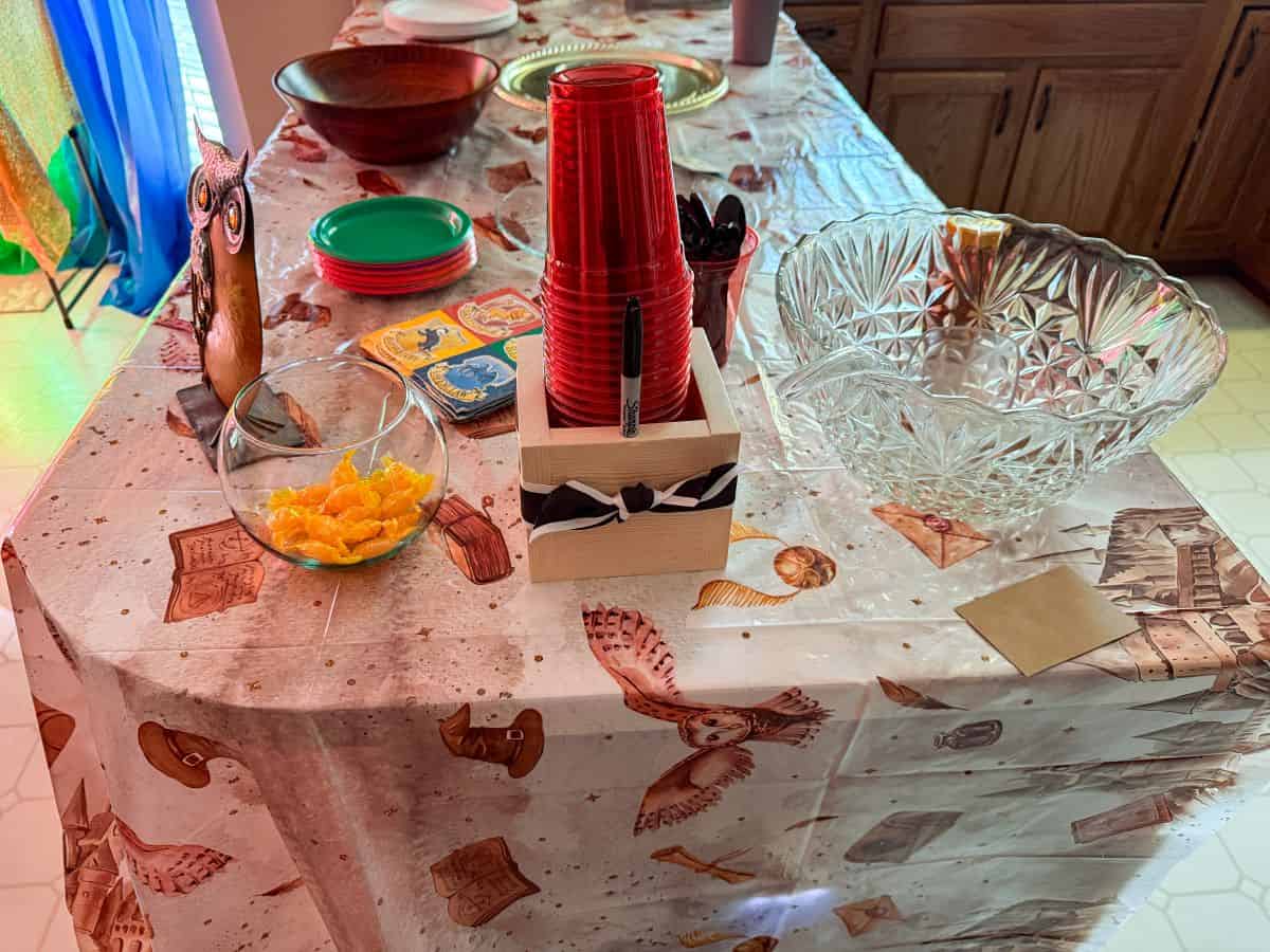 a kitchen peninsula with a Harry Potter tablecloth and other party supplies on top