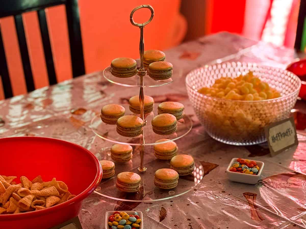a 3-tiered server with gold macarons on a Harry Potter table