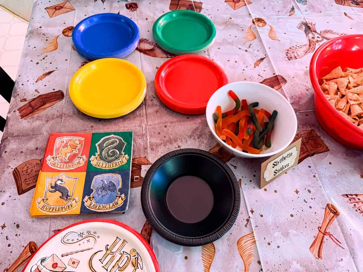 Harry Potter plates and napkins on a table next to blue, green, yellow and red snack plates
